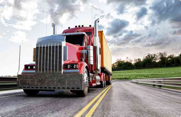 Red semi truck driving on road